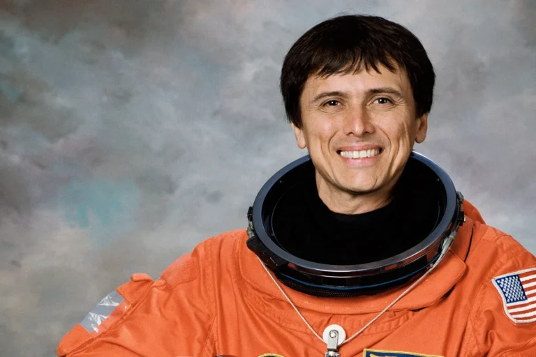 Official NASA portrait of astronaut Franklin Chang-Díaz in an orange launch suit